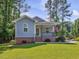 Close up of the front porch with brick base, railing and American flag at 707 Lakewood Dr, Siler City, NC 27344