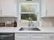 Bright kitchen featuring a stainless steel sink, quartz countertops, and a view of the backyard at 707 Lakewood Dr, Siler City, NC 27344