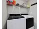 Laundry room features modern washer and dryer, storage shelf, and hanging hooks at 707 Lakewood Dr, Siler City, NC 27344