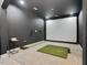 Carpeted recreation room features a golf simulator with projector screen and putting green at 707 Lakewood Dr, Siler City, NC 27344
