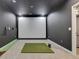Carpeted recreation room features a golf simulator with projector screen and putting green at 707 Lakewood Dr, Siler City, NC 27344