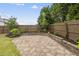 Charming backyard featuring stone patio surrounded by lush greenery and a wooden fence at 817 Ember Dr, Durham, NC 27703