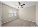 Empty bedroom with neutral walls, carpet flooring, a ceiling fan, and a large window at 817 Ember Dr, Durham, NC 27703