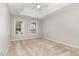 Bedroom with a trey ceiling, carpeted floor, and two windows overlooking the front yard at 8512 Erinsbrook Dr, Raleigh, NC 27617