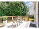 Wooden deck with table, chairs, and an outdoor rug overlooking greenery at 8512 Erinsbrook Dr, Raleigh, NC 27617