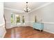 Bright dining room featuring hardwood floors, a bay window, crown molding, and a stylish chandelier at 8512 Erinsbrook Dr, Raleigh, NC 27617