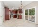 Kitchen features stainless steel appliances, dark cabinetry, tile flooring, and access to the deck at 8512 Erinsbrook Dr, Raleigh, NC 27617