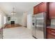 Modern kitchen view, stainless steel refrigerator, and the living room in a well-lit home at 8512 Erinsbrook Dr, Raleigh, NC 27617