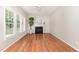 Bright living room features hardwood floors, a fireplace, and large windows that offer great natural light at 8512 Erinsbrook Dr, Raleigh, NC 27617