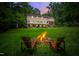 Nighttime view of a backyard firepit, with cozy chairs and a peaceful, inviting ambiance at 8608 Valley Brook Dr, Raleigh, NC 27613