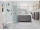 Contemporary bathroom with marble tile, glass-enclosed shower, and gray vanity with double sinks at 8608 Valley Brook Dr, Raleigh, NC 27613
