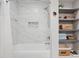 Bathroom showcasing a white-tiled shower and functional shelving at 8608 Valley Brook Dr, Raleigh, NC 27613