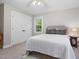 Cozy bedroom featuring a bed with upholstered headboard, two windows and a closet with white doors at 8608 Valley Brook Dr, Raleigh, NC 27613
