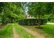 Long driveway lined with lush trees and greenery leading to a beautiful home at 8608 Valley Brook Dr, Raleigh, NC 27613