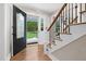 Inviting foyer featuring hardwood floors, a staircase with iron railings, and a decorative front door at 8608 Valley Brook Dr, Raleigh, NC 27613