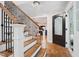 Elegant foyer featuring hardwood floors, a staircase with iron railings, and plenty of natural light at 8608 Valley Brook Dr, Raleigh, NC 27613