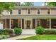 Inviting front porch featuring classic brick columns, a porch swing, and beautiful landscaping at 8608 Valley Brook Dr, Raleigh, NC 27613
