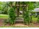 Charming garden bench under a pergola, surrounded by lush greenery, creating a serene outdoor retreat at 8608 Valley Brook Dr, Raleigh, NC 27613