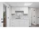 Basement kitchen with clean white cabinets, stone countertops, and stainless steel sink at 8608 Valley Brook Dr, Raleigh, NC 27613