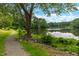 Scenic view of a tranquil lake with a walking path surrounded by lush trees and greenery at 8608 Valley Brook Dr, Raleigh, NC 27613