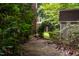 Stone pathway with natural archway leading through lush greenery, creating a serene garden experience at 8608 Valley Brook Dr, Raleigh, NC 27613