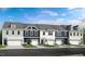 Charming townhome showcases a well-maintained front exterior with a two car garage and manicured landscaping at 8732 Wardle Ct, Wake Forest, NC 27587