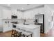 Modern kitchen featuring white cabinets, stainless steel appliances, and a spacious center island at 8732 Wardle Ct, Wake Forest, NC 27587