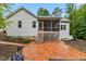 An exterior shot shows a cozy backyard patio with steps leading to a screened porch at 100 Lexington Ave, Zebulon, NC 27597