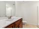 Well-lit bathroom with a cherry vanity, quartz countertop, and white tile flooring at 100 Lexington Ave, Zebulon, NC 27597