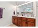 Bright bathroom with dual sinks, wooden cabinets, and plenty of counter space at 100 Lexington Ave, Zebulon, NC 27597