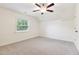 Bright bedroom featuring a ceiling fan, neutral carpet, and natural light from a window at 100 Lexington Ave, Zebulon, NC 27597