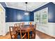 Stylish dining room with a dark blue accent wall, wainscoting, and a modern chandelier at 100 Lexington Ave, Zebulon, NC 27597