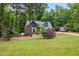 Charming home exterior with stone accents, lush landscaping, and a spacious front yard at 100 Lexington Ave, Zebulon, NC 27597