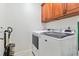 Efficient laundry room with front load washer and dryer, and cherry cabinets above at 100 Lexington Ave, Zebulon, NC 27597