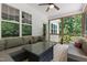 This screened porch boasts comfortable seating with ceiling fan overlooking backyard trees at 100 Lexington Ave, Zebulon, NC 27597
