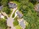 Aerial view of a neighborhood, showcasing the layout of houses, roads, and lush green trees at 104 Odessa Cir, Cary, NC 27513