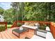 Staged back deck area featuring stylish outdoor furniture and a serene wooded view at 104 Odessa Cir, Cary, NC 27513