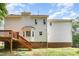 View of home's back exterior featuring a walkout deck, brick foundation, and windows at 104 Odessa Cir, Cary, NC 27513