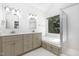Primary bathroom features double vanity, soaking tub under a window, and glass shower at 104 Odessa Cir, Cary, NC 27513