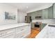 Bright kitchen featuring stainless appliances, white marble counters, and modern green cabinetry at 104 Odessa Cir, Cary, NC 27513