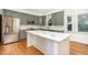 Modern kitchen with stainless steel appliances, center island, and light green cabinets at 104 Odessa Cir, Cary, NC 27513