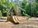 Playground featuring a green slide, wood slides, climbing structure, and mulch at 104 Odessa Cir, Cary, NC 27513