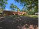 Large backyard showing the brick house, wooden deck, storage shed, and mature tree coverage at 106 N Lakeside Dr, Smithfield, NC 27577