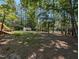Spacious backyard with mature trees, a lake, a shed, and a covered area by the water, offering privacy at 106 N Lakeside Dr, Smithfield, NC 27577