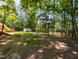 Spacious backyard with mature trees, a lake, a shed, and a covered area by the water, offering privacy at 106 N Lakeside Dr, Smithfield, NC 27577