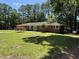 Charming brick home with a well-manicured lawn, mature trees, and an American flag at 106 N Lakeside Dr, Smithfield, NC 27577