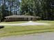 Brick home featuring a well-kept lawn, mature trees and shrubs, set beneath a bright blue sky at 106 N Lakeside Dr, Smithfield, NC 27577