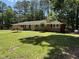 Charming brick home with a well-manicured lawn, mature trees, and an American flag at 106 N Lakeside Dr, Smithfield, NC 27577