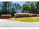 Well-maintained brick home with an outbuilding and ample parking space against a backdrop of mature trees at 106 N Lakeside Dr, Smithfield, NC 27577