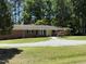 Classic brick home with tidy landscaping, set against a backdrop of mature trees and blue sky at 106 N Lakeside Dr, Smithfield, NC 27577